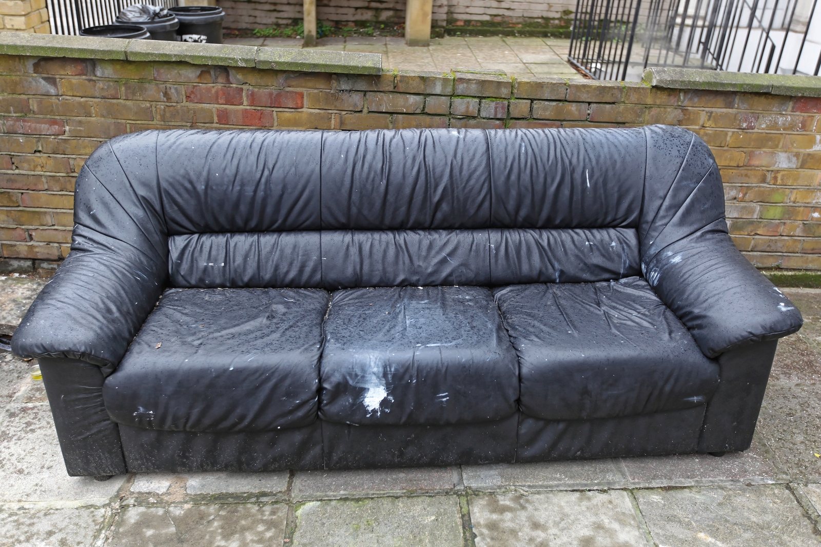 Black leather couch and sofa set out at the curb for pickup
