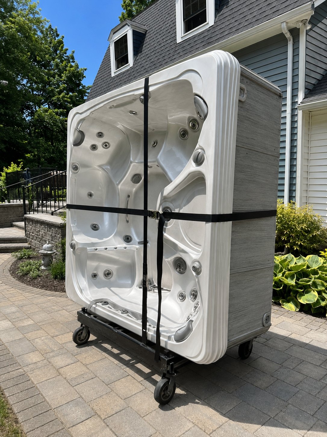 Old hot tub strapped to a dolly for haul-away