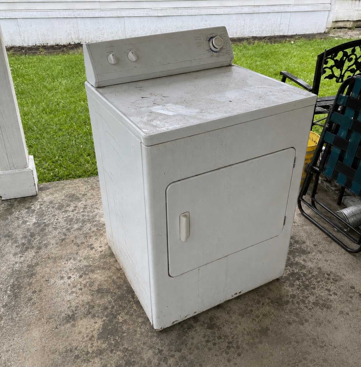 Old dryer sitting on a driveway for pickup